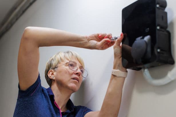 Certified female electrician finishing installation of home EV charger
