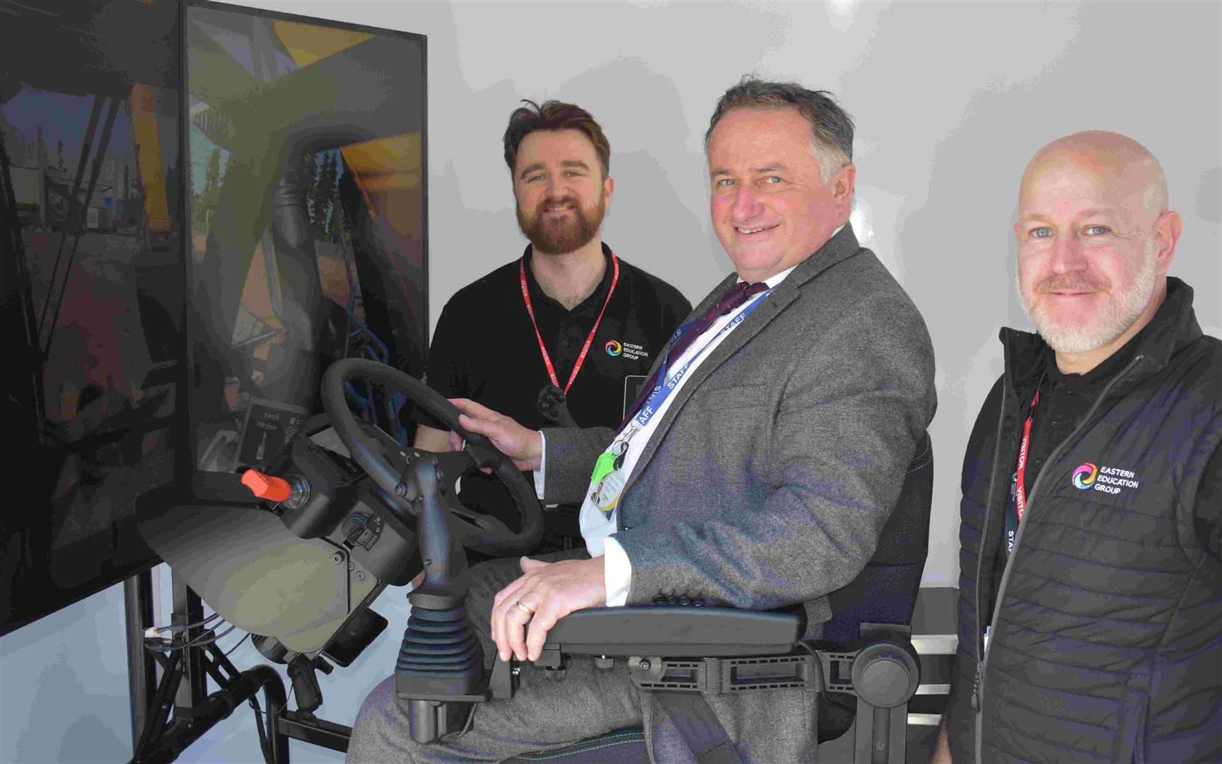 Principal of Stowupland High School, Lee Walker, tries out the sim van with representatives from Eastern Education Group